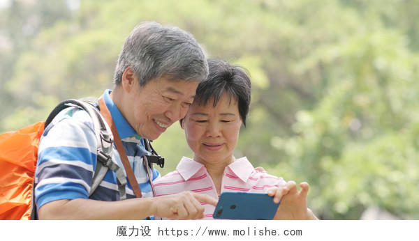 亚洲老夫妇去乡村旅游和使用手机晚年幸福微笑的老人